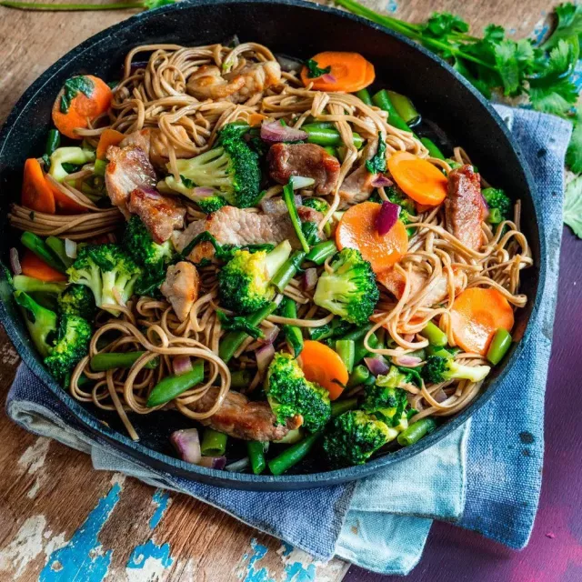 Жареная лапша со свининой и овощами